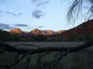 red rocks framed by tree and fence